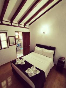 a bedroom with a bed with two white flowers on it at Hospederia Sandaned in Villa de Leyva