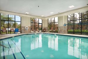 a large swimming pool with blue water in a building at Hampton Inn Ann Arbor-South in Ann Arbor