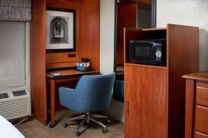 a room with a desk and a chair and a television at Hampton Inn Ann Arbor-South in Ann Arbor