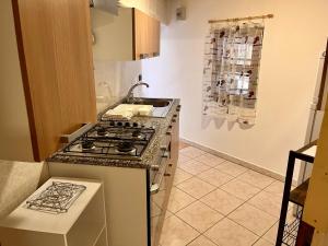 una cocina con estufa y encimera en Rustico Porto Pino 30 mt dalla spiaggia, en Porto Pino