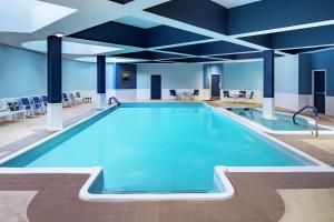 a large swimming pool in a building with blue ceilings at DoubleTree by Hilton Nashua in Nashua
