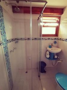 uma casa de banho com um chuveiro e um lavatório. em Hospederia Sandaned em Villa de Leyva