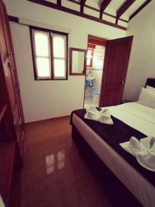 um quarto de hotel com duas camas e uma janela em Hospederia Sandaned em Villa de Leyva