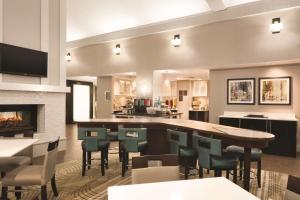 a restaurant with a bar with chairs and a fireplace at Homewood Suites by Hilton Atlanta-Alpharetta in Alpharetta