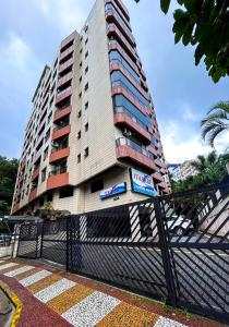 a tall building with a sign in front of it at Flat beira mar da Praia de Itarare em Sao Vicente in São Vicente