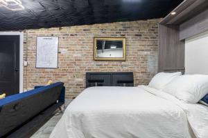 a bedroom with a large bed and a brick wall at London Downtown Home in London