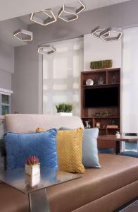 a living room with a couch with blue and yellow pillows at Home2 Suites By Hilton Atlanta Perimeter Center in Atlanta