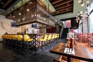 un restaurant avec un bar et des chaises jaunes dans l'établissement Hilton Garden Inn Atlanta Downtown, à Atlanta