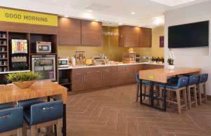 a restaurant with wooden tables and blue chairs at Home2 Suites By Hilton Atlanta Perimeter Center in Atlanta