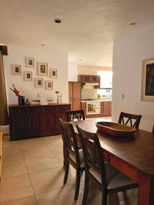 een keuken en eetkamer met een houten tafel en stoelen bij LAS ALAMEDAS Departamentos céntricos con estacionamiento privado in Guanajuato