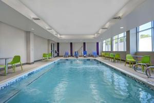 una piscina con sillas, mesas y sillas en un edificio en Home2 Suites by Hilton Atlanta Airport North en Atlanta