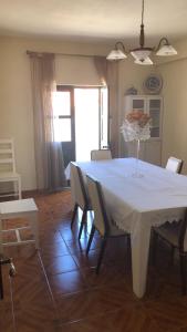 a dining room with a white table and chairs at SPA - Casa do Avo BESELGA in Santo Amaro