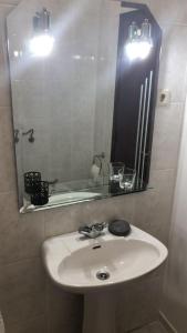 een badkamer met een witte wastafel en een spiegel bij SPA - Casa do Avo BESELGA 