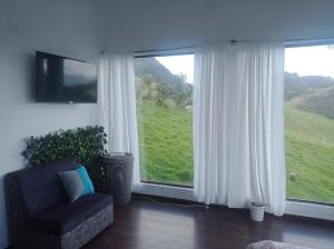 een woonkamer met een stoel en een groot raam bij Vista Hermosa Suite 