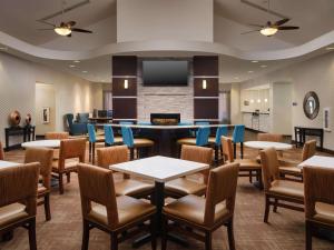 ein Restaurant mit Tischen und Stühlen und einem Flachbild-TV in der Unterkunft Homewood Suites by Hilton Atlanta NW/Kennesaw-Town Center in Kennesaw