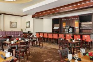 ein Restaurant mit Tischen und Stühlen und eine Bar in der Unterkunft DoubleTree by Hilton Atlanta Northeast/Northlake in Atlanta