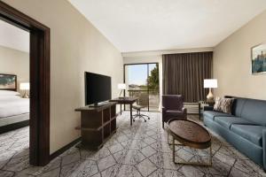 ein Hotelzimmer mit einem Sofa, einem TV und einem Bett in der Unterkunft DoubleTree by Hilton Atlanta Northeast/Northlake in Atlanta