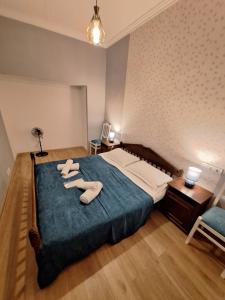 Un dormitorio con una cama con dos pares de zapatos. en Mery's Family Apartment en Tiflis