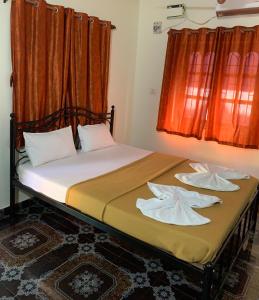 a bedroom with a bed with two pillows on it at Casa De Calangute Inn in Calangute