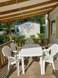 einen weißen Tisch und Stühle auf einer Terrasse in der Unterkunft Mobil-House Parc des Roches in Saint-Chéron