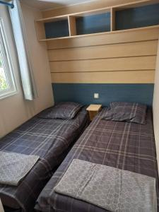 - une chambre avec 2 lits dans une petite pièce dans l'établissement Mobil-House Parc des Roches, à Saint-Chéron