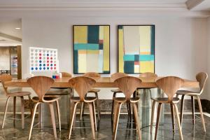 a dining room with a wooden table and stools at The American Hotel Atlanta Downtown, Tapestry by Hilton in Atlanta