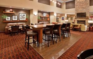 un restaurante con un bar con mesa y sillas en Hampton Inn & Suites Watertown en Watertown
