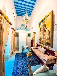 uma sala de estar com um sofá e uma pintura na parede em Dar Badiaa em Sousse