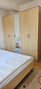 Schlafzimmer mit einem Bett und Holzschränken in der Unterkunft Apartman stan Konjic in Konjic
