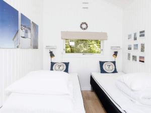 2 Betten in einem Zimmer mit weißen Wänden und einem Fenster in der Unterkunft Holiday home Fjerritslev IX in Fjerritslev