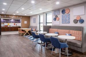 a restaurant with tables and chairs and a couch at Hampton Inn Auburn in Auburn