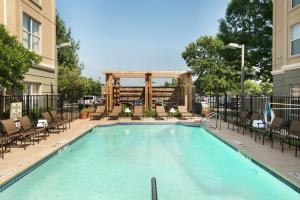 einen großen Pool mit Stühlen und einem Pavillon in der Unterkunft Homewood Suites by Hilton Austin South in Austin