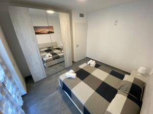 1 dormitorio con cama a cuadros y espejo en Casa Mattia, en Bellano