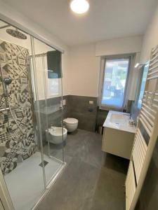 a bathroom with a shower and two sinks and a toilet at Casa Mattia in Bellano
