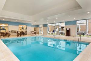 a swimming pool in a hotel with tables and chairs at Homewood Suites By Hilton Augusta in Augusta
