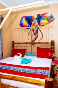 a bedroom with a bed with an elephant on the wall at PALM - 2minutes walk to the beach in Nungwi