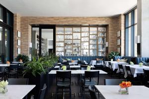 a dining room with tables and chairs and windows at Canopy By Hilton Austin Downtown in Austin