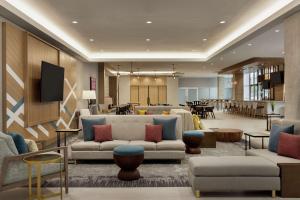 a lobby with couches and a waiting room with tables at Hilton Garden Inn Austin North-Near the Domain, TX in Austin