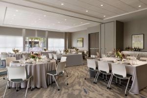 una sala de banquetes con mesas y sillas blancas en Hilton Garden Inn Austin North-Near the Domain, TX, en Austin