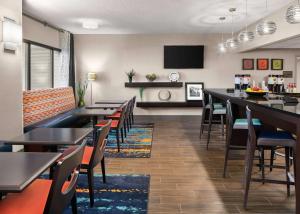 una sala da pranzo con tavoli, sedie e TV di Hampton Inn Austin North ad Austin