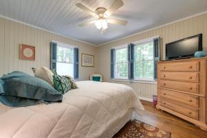1 dormitorio con 1 cama, ventilador de techo y TV en Secluded Hamilton Cabin Retreat with Private Lake!, en Hamilton