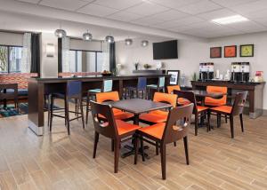 a restaurant with tables and chairs and a bar at Hampton Inn Austin North in Austin
