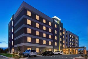 an office building with cars parked in a parking lot at Home2 Suites By Hilton Asheville Airport in Arden