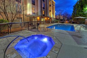a swimming pool with blue water in front of a building at Hampton Inn and Suites Asheville Airport in Fletcher