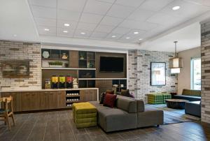 Home2 Suites By Hilton Asheville Airport في Arden: غرفة معيشة مع أريكة وتلفزيون