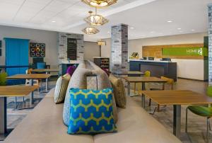 uma cafetaria com mesas e um banco com almofadas em Home2 Suites By Hilton Asheville Airport em Arden