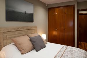 サンタクルス・デ・テネリフェにあるSanta Cruz Luxe Apartmentのベッドルーム1室(ベッド1台付)、木製キャビネットが備わります。