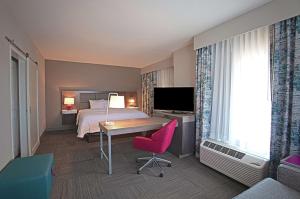 Habitación de hotel con cama, escritorio y TV. en Hampton Inn & Suites Asheville Biltmore Area en Asheville