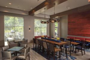 uma sala de jantar com mesas, cadeiras e janelas em Hampton Inn & Suites-Asheville Biltmore Village, NC em Asheville