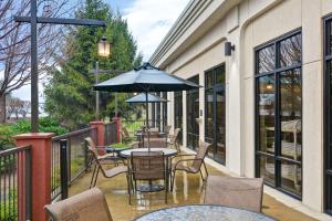 a patio with tables and chairs and an umbrella at Hampton Inn Hendersonville in Hendersonville